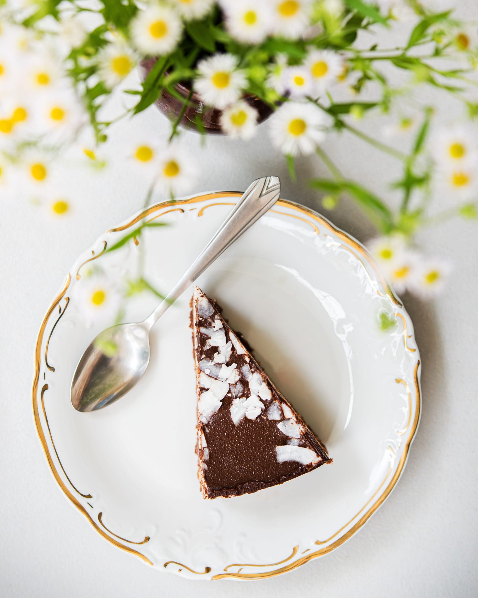 Fatia de bolo de chocolate em prato de porcelana com flores