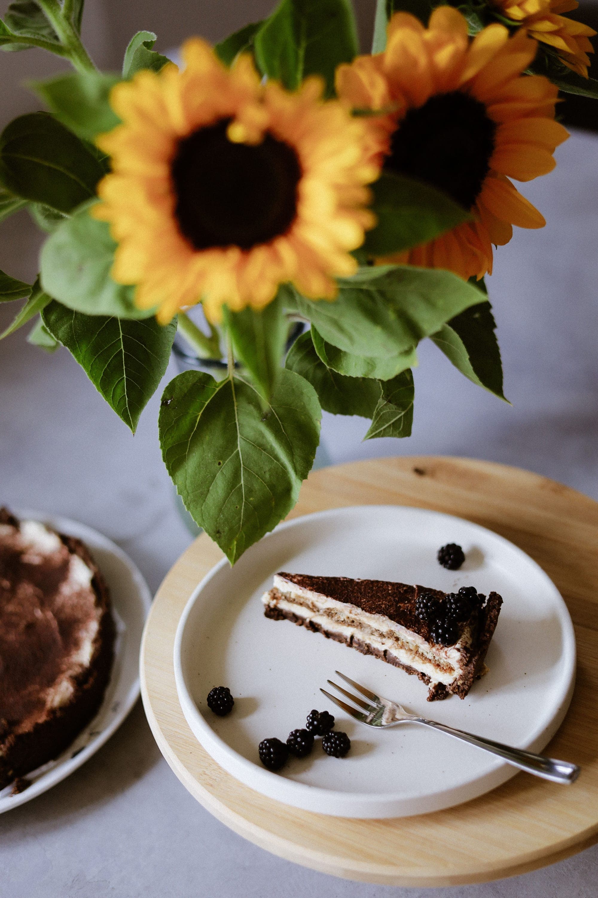 Fatia de bolo com frutas vermelhas e girassóis